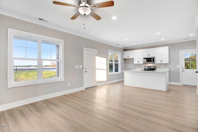 kitchen with crown molding, light wood-type flooring, white cabinetry, and stainless steel appliances