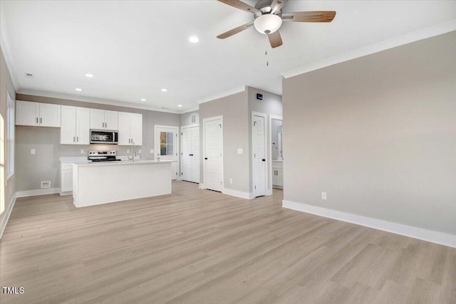 kitchen with white cabinetry, stainless steel appliances, crown molding, an island with sink, and light wood-type flooring