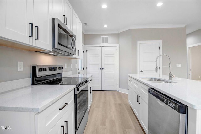 kitchen featuring stainless steel appliances, white cabinetry, light hardwood / wood-style floors, and sink