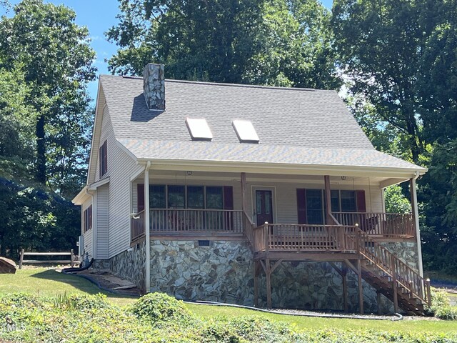 view of front of house featuring covered porch and a front lawn