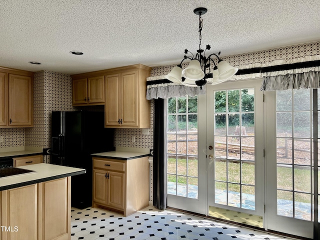 kitchen with a chandelier, a textured ceiling, black refrigerator with ice dispenser, and decorative light fixtures