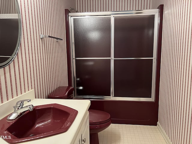 full bathroom featuring enclosed tub / shower combo, vanity, and toilet