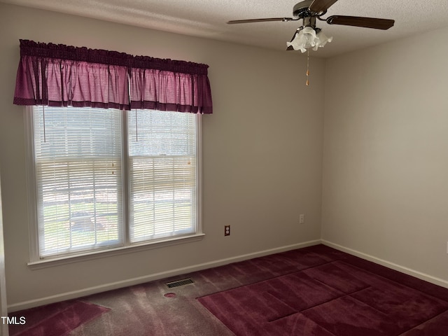 carpeted spare room with ceiling fan and a textured ceiling