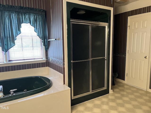 bathroom featuring separate shower and tub and toilet