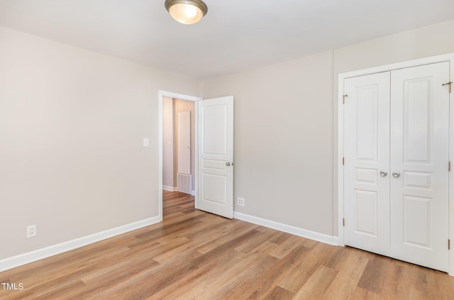 unfurnished bedroom featuring a closet and light hardwood / wood-style floors