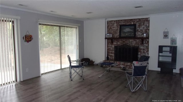 living room with a stone fireplace, hardwood / wood-style floors, and ornamental molding