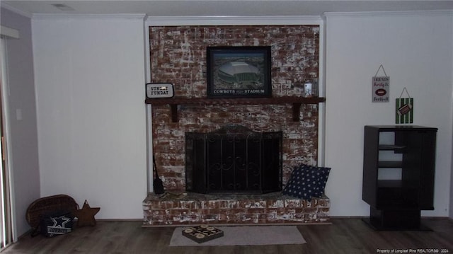 living room with wood-type flooring, a brick fireplace, and ornamental molding