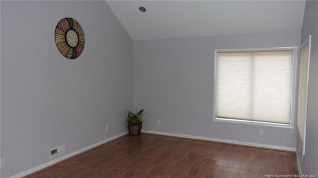 empty room with dark hardwood / wood-style floors and vaulted ceiling