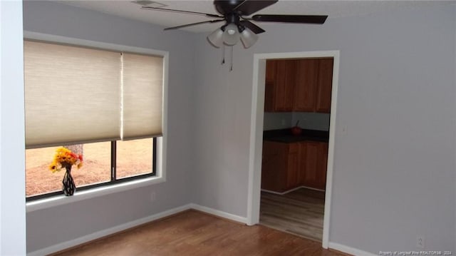 unfurnished room with hardwood / wood-style floors and ceiling fan