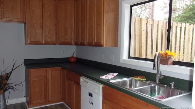 kitchen with a wealth of natural light, sink, dishwasher, and hardwood / wood-style flooring