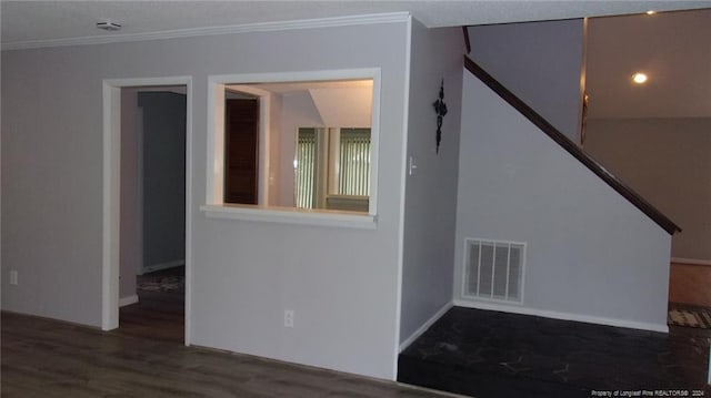 empty room featuring dark wood-type flooring and crown molding