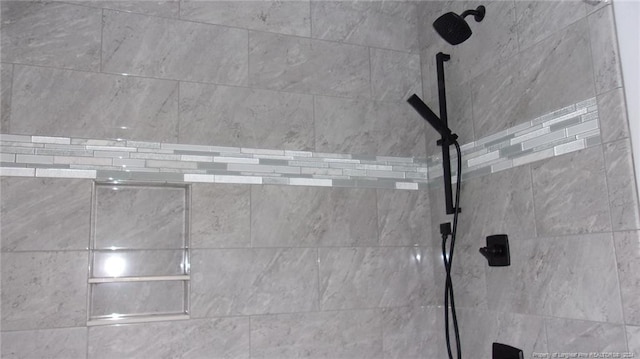 interior details featuring tiled shower