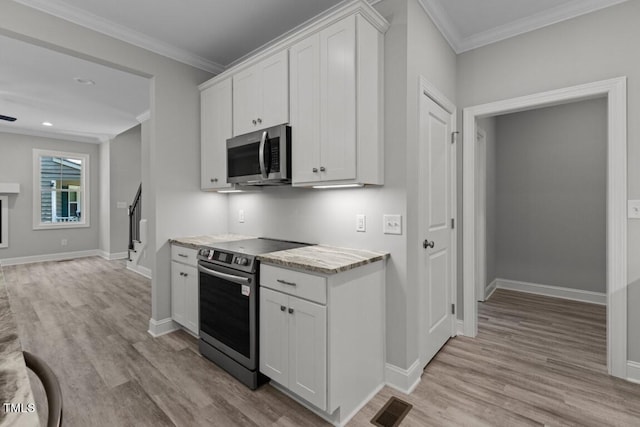 kitchen with white cabinetry, stainless steel appliances, and ornamental molding