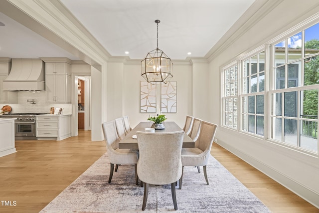 dining area with light wood finished floors, crown molding, a chandelier, and recessed lighting