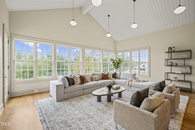 living area featuring light wood-style floors, plenty of natural light, beamed ceiling, and high vaulted ceiling