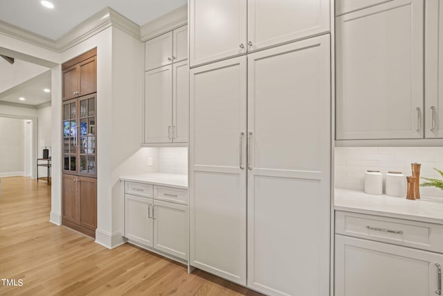 kitchen with light countertops, decorative backsplash, light wood-style flooring, and recessed lighting
