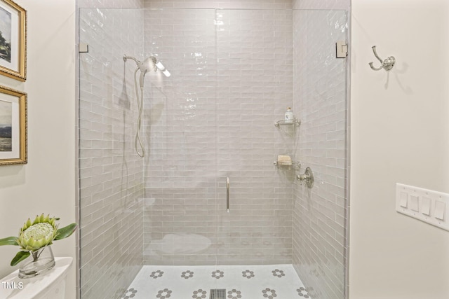 bathroom featuring a stall shower and toilet