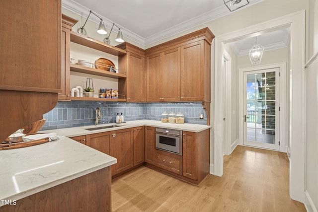 kitchen featuring light wood-style flooring, stainless steel oven, a sink, open shelves, and brown cabinets