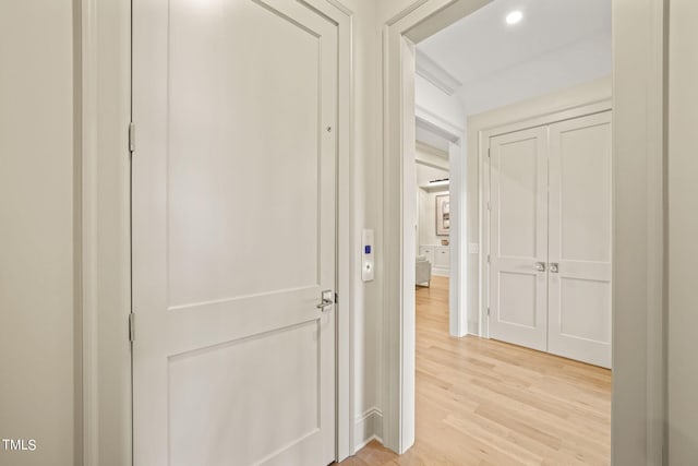 hallway featuring light wood-style flooring and recessed lighting