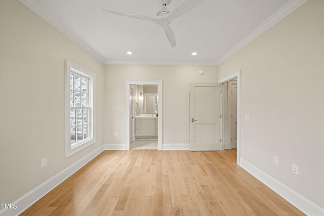 spare room featuring a ceiling fan, light wood-style floors, crown molding, and baseboards