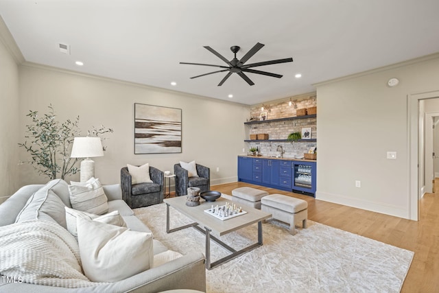living area featuring a ceiling fan, visible vents, wet bar, light wood-style floors, and wine cooler