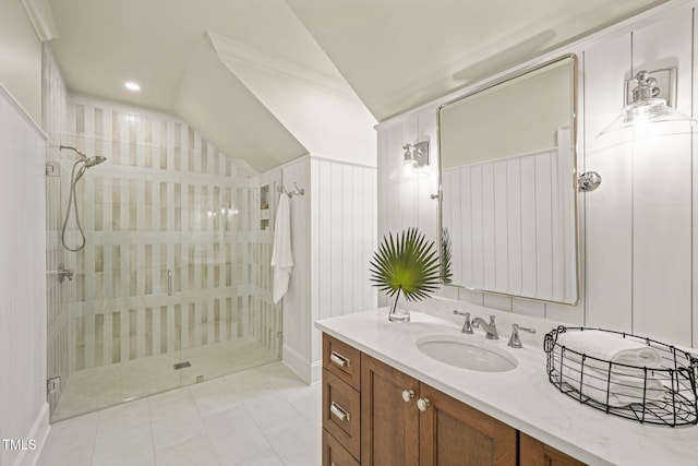 full bathroom with a stall shower, baseboards, tile patterned flooring, lofted ceiling, and vanity