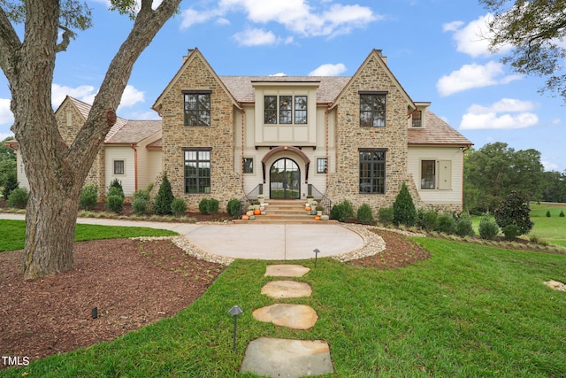 english style home with a front lawn