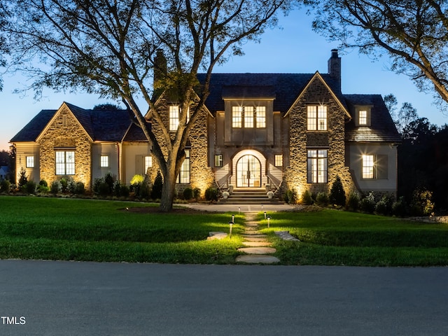 view of front of property with a yard and french doors