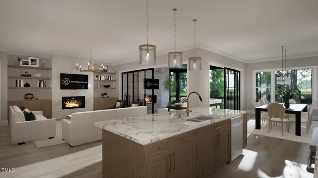 kitchen featuring a large fireplace, a sink, a center island with sink, and pendant lighting