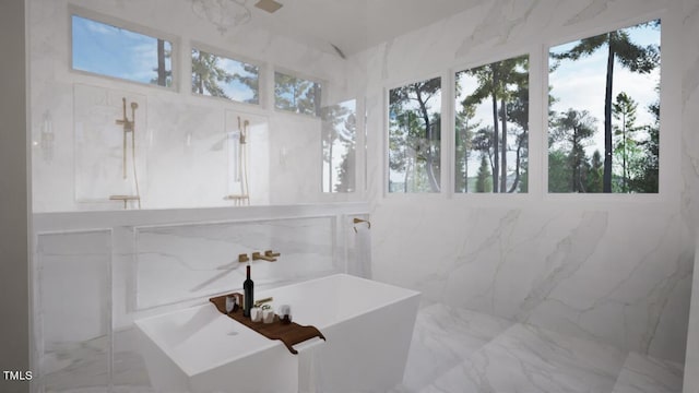 full bathroom featuring a freestanding tub, plenty of natural light, and marble finish floor