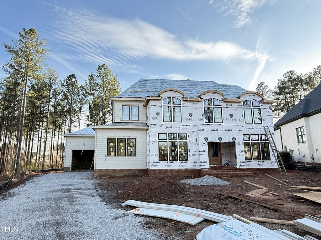 french country home featuring gravel driveway