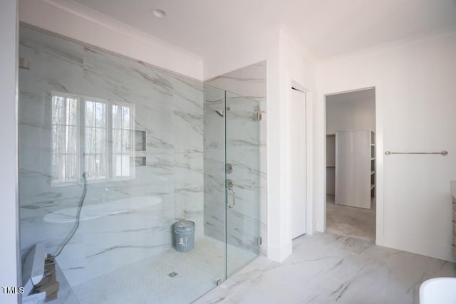 bathroom featuring vanity, ornamental molding, and a shower with door