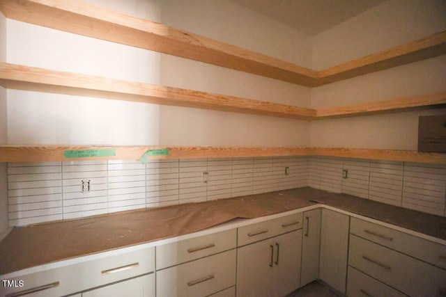 kitchen with decorative backsplash and white cabinetry