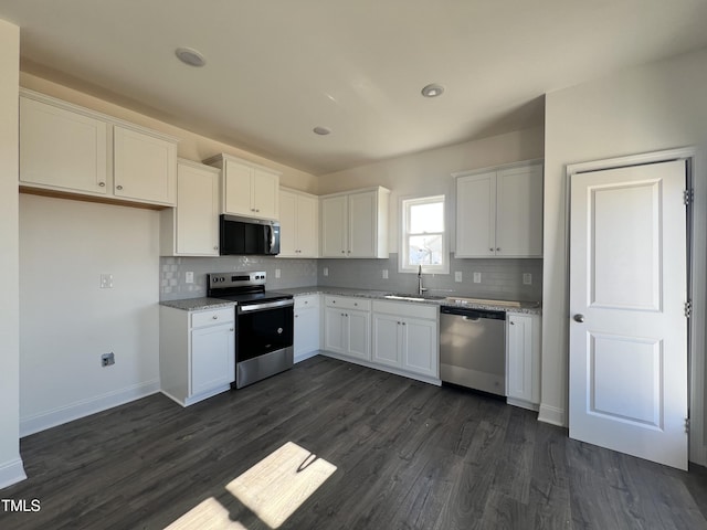 kitchen featuring sink, tasteful backsplash, dark hardwood / wood-style flooring, white cabinetry, and stainless steel appliances