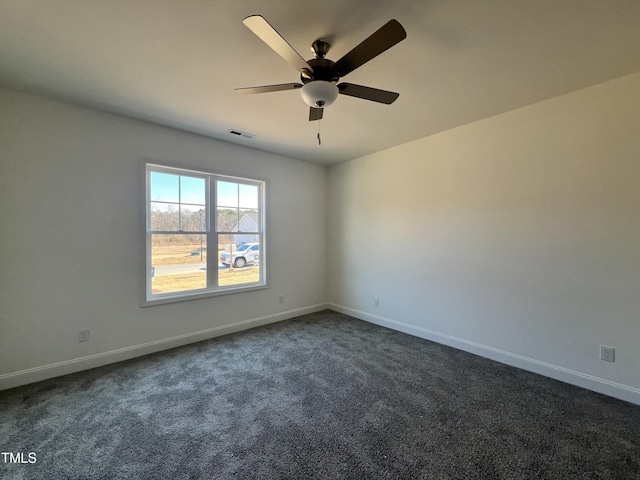 spare room featuring ceiling fan and dark carpet