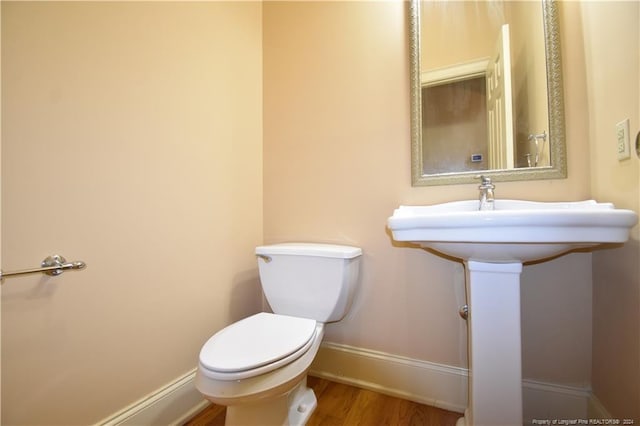 bathroom featuring hardwood / wood-style flooring and toilet