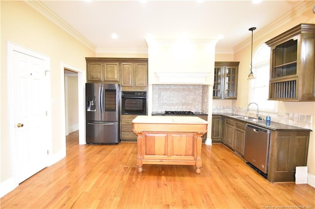 kitchen featuring appliances with stainless steel finishes, decorative light fixtures, tasteful backsplash, and sink