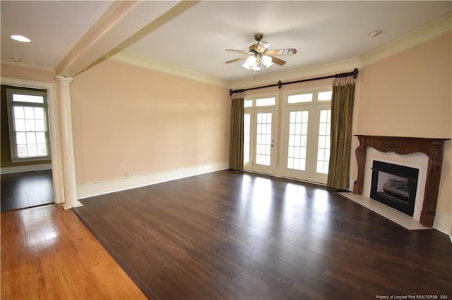 unfurnished living room featuring ceiling fan, decorative columns, hardwood / wood-style floors, a fireplace, and ornamental molding