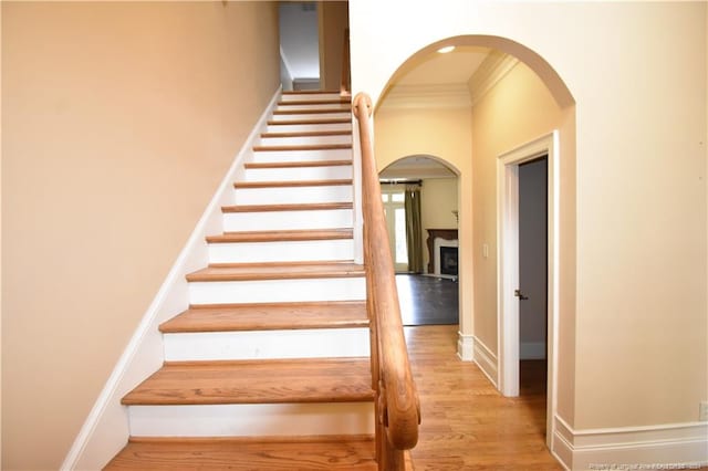 stairs with crown molding and hardwood / wood-style floors