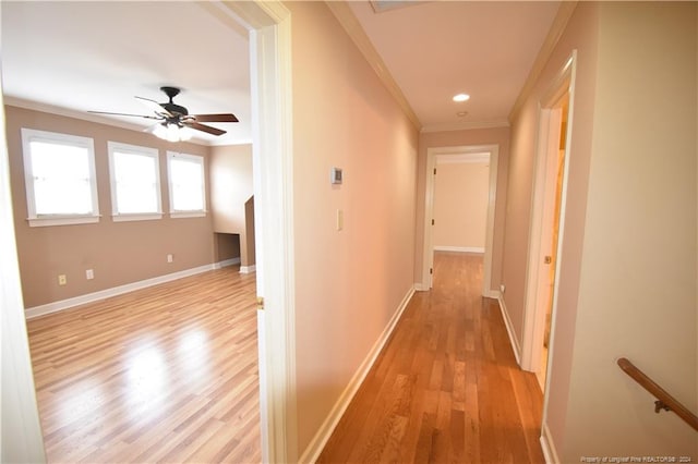 hallway with light wood-type flooring and ornamental molding