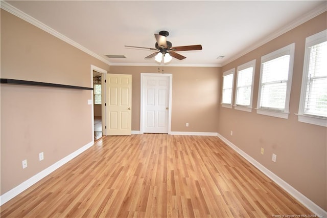 spare room featuring light hardwood / wood-style floors, plenty of natural light, and ornamental molding