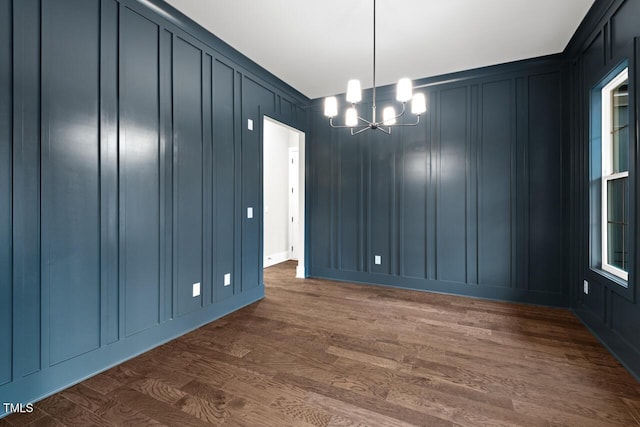 unfurnished dining area featuring dark hardwood / wood-style floors and a notable chandelier