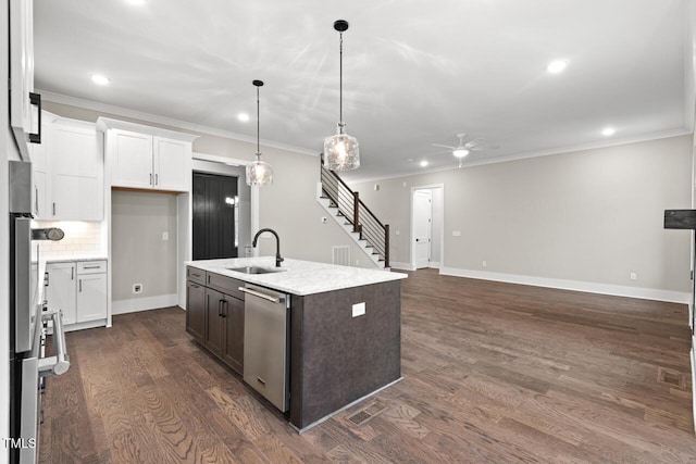 kitchen featuring white cabinetry, decorative light fixtures, stainless steel dishwasher, and an island with sink