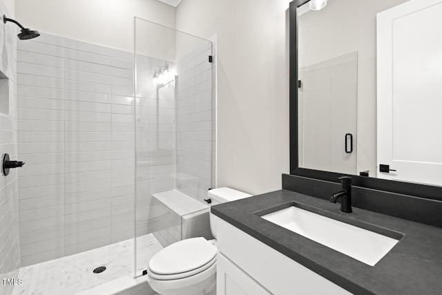 bathroom featuring vanity, toilet, and a shower with door