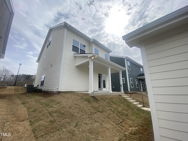 back of house featuring cooling unit and covered porch