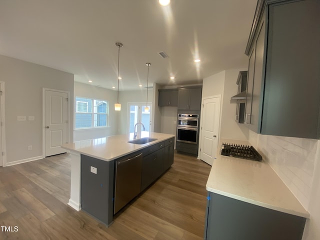 kitchen featuring visible vents, dark wood finished floors, stainless steel appliances, light countertops, and a sink