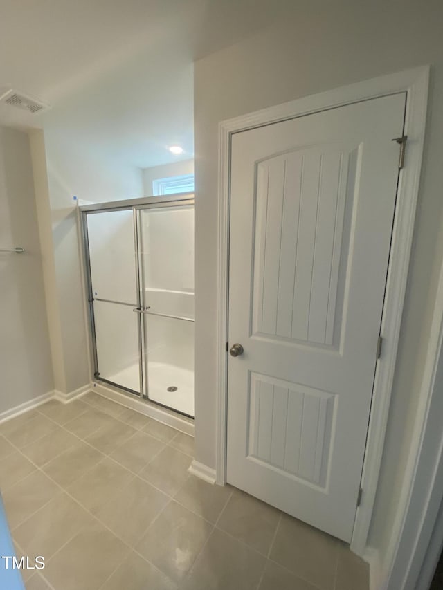 bathroom with baseboards, a stall shower, visible vents, and tile patterned floors