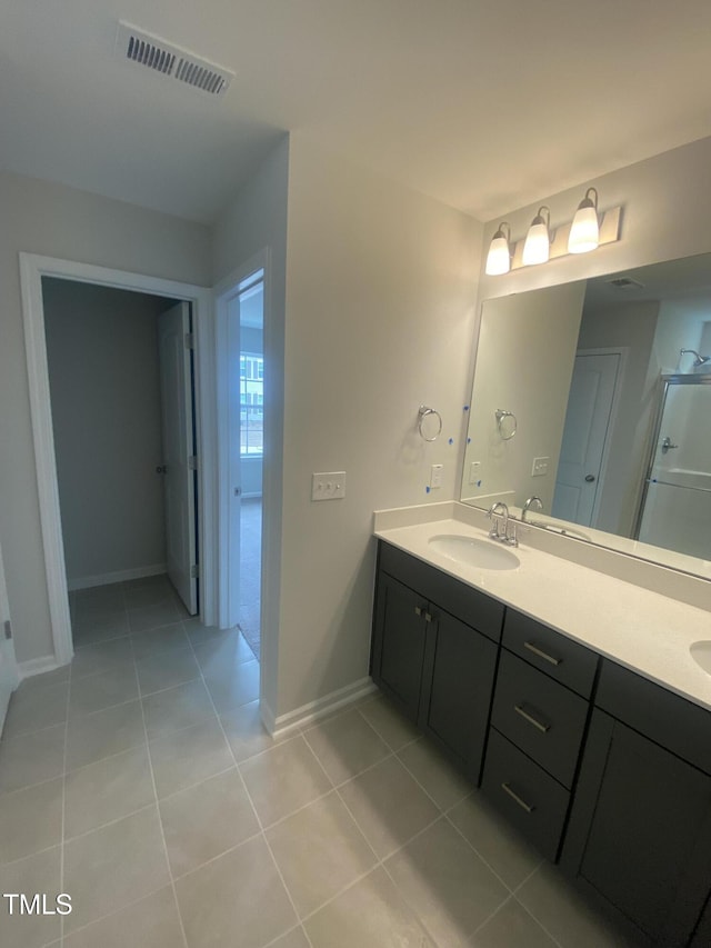 full bathroom featuring a sink, visible vents, baseboards, tile patterned floors, and double vanity