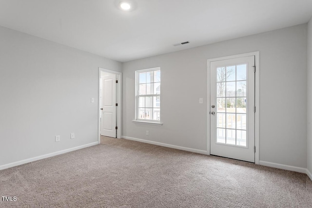 carpeted spare room featuring visible vents and baseboards