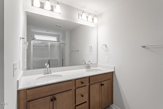 full bathroom with double vanity, a sink, visible vents, and a shower stall